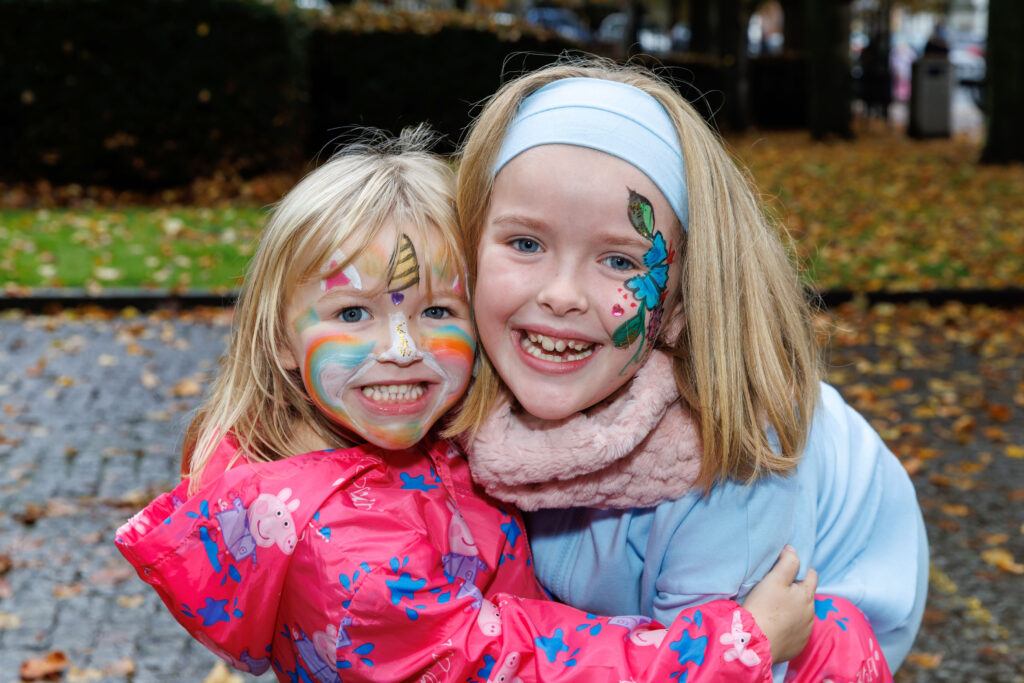 Two smiling girls with faces painted