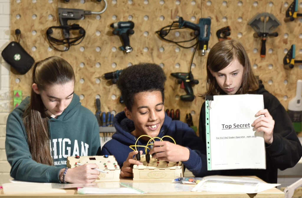 Three teens engaed in code breaking